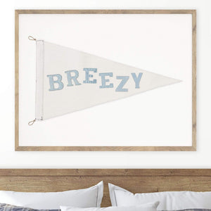 Wall-mounted 'Breezy' nautical flag in a modern bedroom setting, framed above a bed, bringing a calm, coastal charm to the room decor.