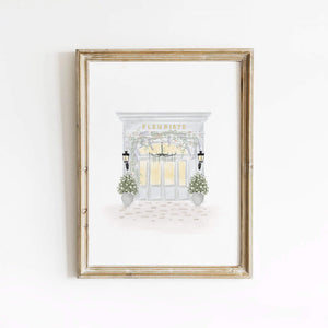 Elegant watercolor print of 'Fleuriste', a Parisian flower shop, framed neatly and displayed in a bright, refined setting, perfect for adding a sophisticated floral touch.