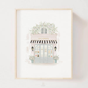 Elegant watercolor print of a Parisian patisserie framed and displayed on a bright, airy wall, enhancing the decor with a touch of French sophistication, by artist Leah Straatsma